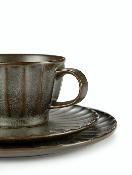 gerillte schwarzte Teetasse auf zwei Untertassen