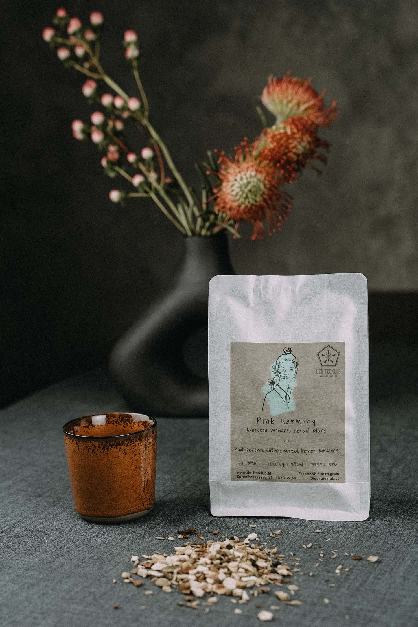 Kräutertee auf Tisch mit blühenden Zweigen im Hintergrund