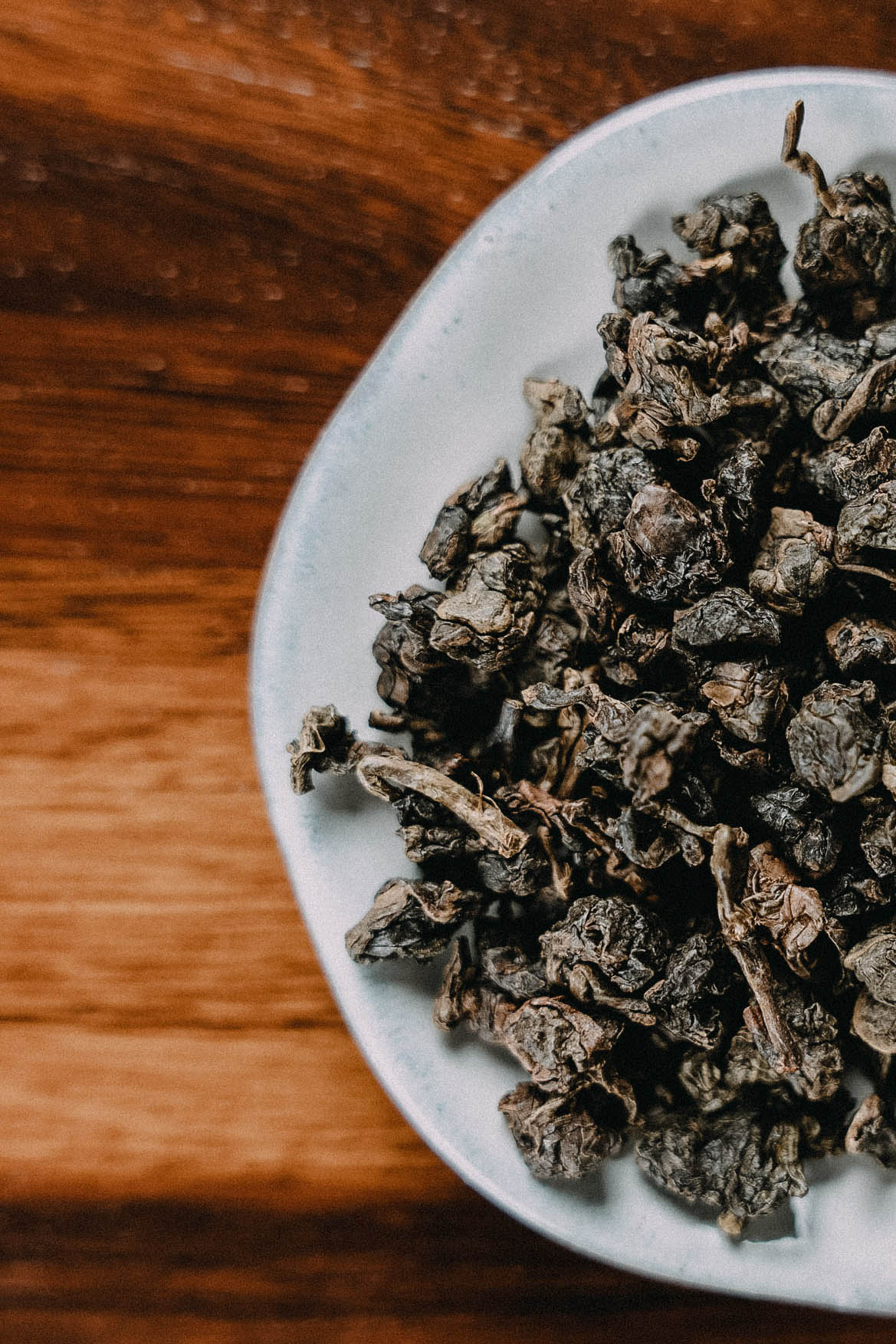 gerollter Oolongtee auf weisser Keramik