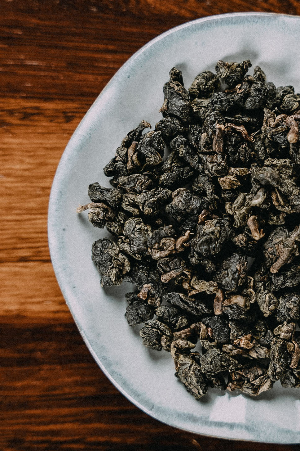 feingerollter Oolongtee auf weissem Teller