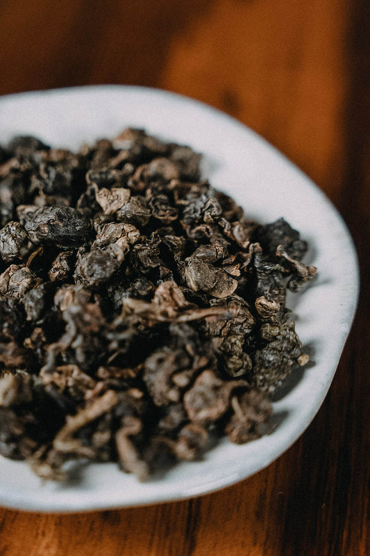 gerollter Oolongtee auf Holzhintergrund